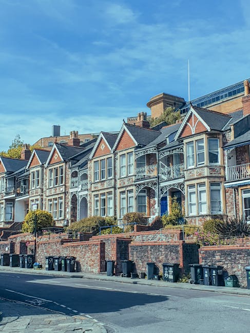 A row of traditional multi-storey Victorian houses with grey stone facades, pitched roofs, and tall windows, located along a street in Waddon, CR0. In the foreground, there is a grassy area with a few